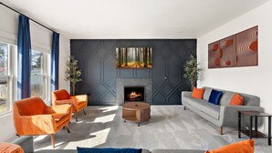 Una sala de estar moderna con chimenea, dos sofás y una mesa de centro.