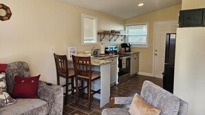 A compact living space with a kitchen, two sofas, a dining table, and a ceiling fan. - Enjoy a piece of home in a cozy inviting space. (Waynesboro)