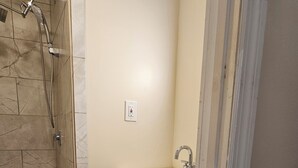 A bathroom with a shower, sink, and patterned floor tiles. - Enjoy a piece of home in a cozy inviting space. (Waynesboro)