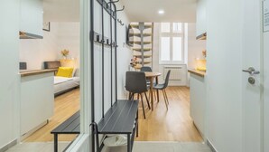 A modern, well-lit room with a dining area, a sofa, and a staircase leading to an upper floor. - Čelakovsky by Interhome (Prague centre)