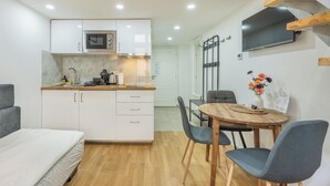 A compact living space with a kitchenette, dining area, and a bed. - Čelakovsky by Interhome (Prague centre)