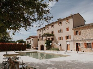 A building with a pool, stone facade, and wooden shutters. - Poropati by Interhome (Grožnjan)