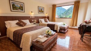 A hotel room with two beds, a wooden headboard, a large window with a mountain view, and a small table with flowers. - Boutique Inka Hotel (Ollantaytambo)