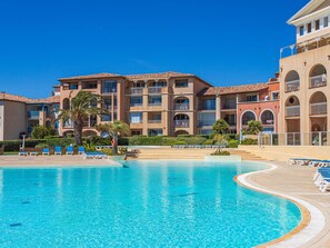 A hotel with a large swimming pool, multiple balconies, and a clear blue sky. - Les Rivages de Coudoulière by Interhome (Six Fours La Coudoulière)