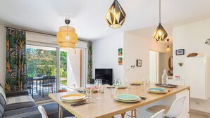 Eine moderne Küche mit Essbereich, großen Fenstern und Blick ins Freie.