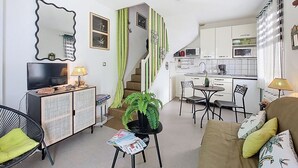 Ein gemütlicher, kompakter Wohnbereich mit Küchenzeile, Essbereich und einer Sitzecke mit Sofa und Sesseln.