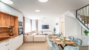 A modern apartment with a dining area, sofa, kitchen, and staircase. - Mediterranee Oliva by Interhome (Poreč/Funtana)