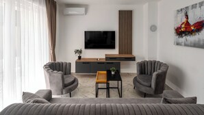 A modern living room with a sofa, two armchairs, a coffee table, a TV, and a painting on the wall. - Mediterranee Oliva by Interhome (Poreč/Funtana)