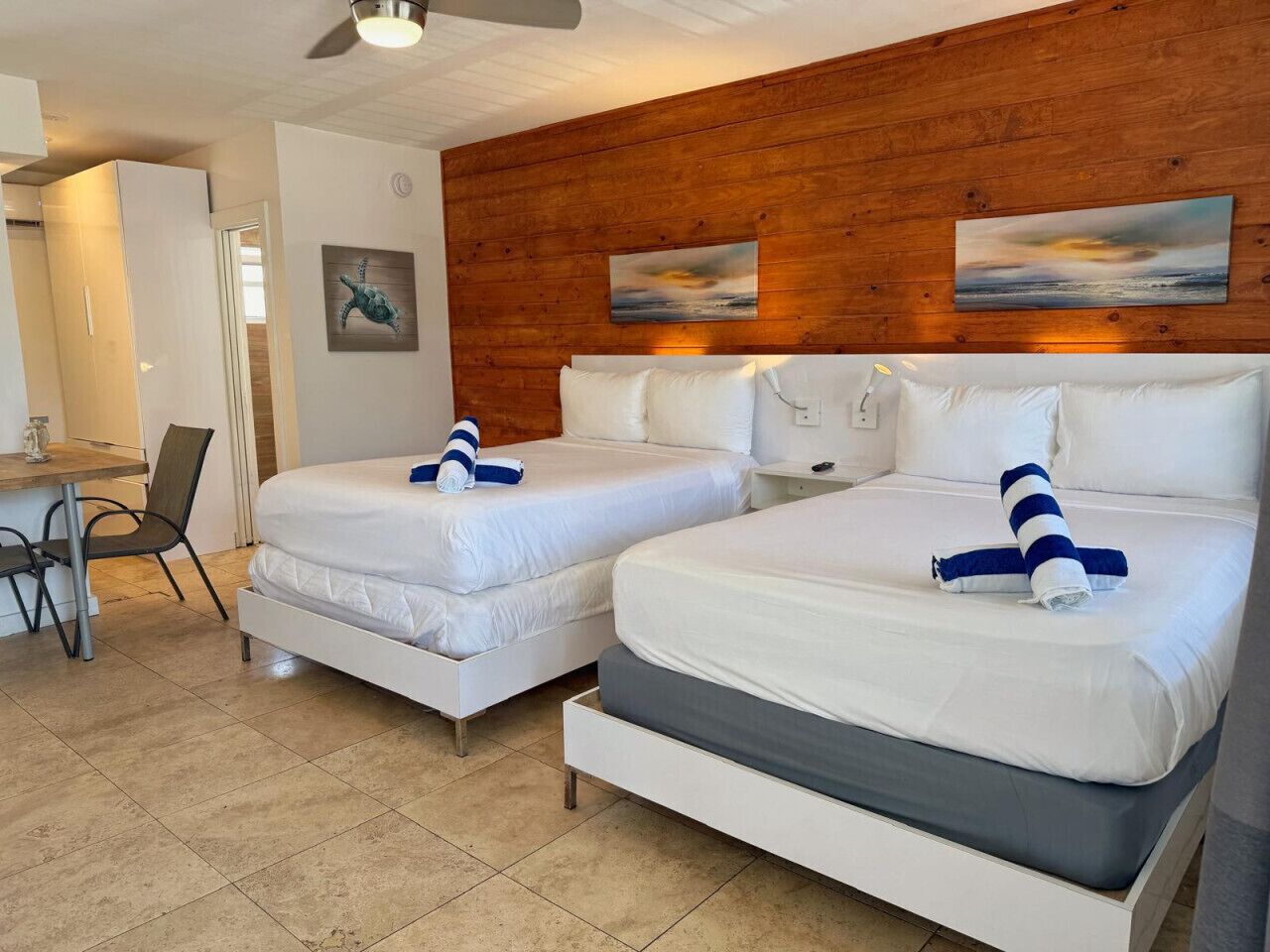 Habitación de hotel con dos camas, un escritorio y una silla.