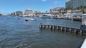 Un port de plaisance avec des bateaux, un quai et, au fond, un grand bâtiment d’hôtel.