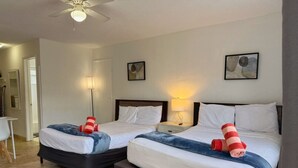 Une chambre d’hôtel avec deux lits, un bureau et une chaise.