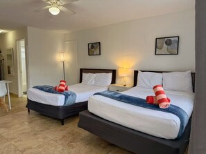 A hotel room with two beds, a desk, and a chair. - Sunny Studio by the Pool • Near Beach & Dining #6 (Pompano Beach)