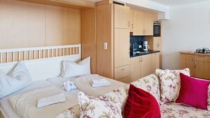Ein Hotelzimmer mit Bett, einer Sitzecke, einer Küchenzeile und einem kleinen Essbereich.