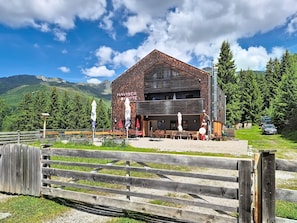 A building with a sign reading 'NAVISER LITTTE' and outdoor seating. - Naviser Hütte by Interhome (Navis)