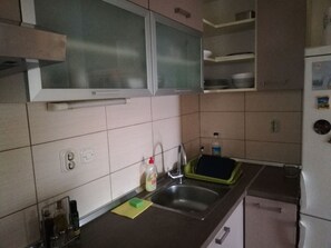 A kitchen with a sink, a dish rack, and cabinets. - Zentrale Ferienwohnung mit überdachtem Balkon by Interhome (Crno)