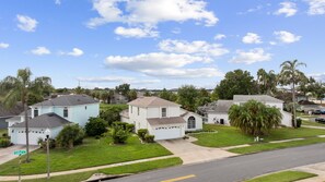 Un quartier résidentiel avec des maisons, une rue et un ciel dégagé.