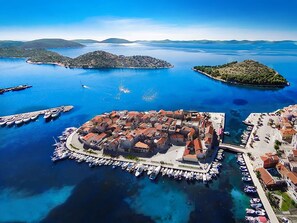 An aerial view of a coastal town with a marina, surrounded by clear blue waters and small islands. - Nikoleta by Interhome (Vodice/Tribunj)