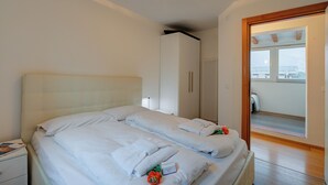 Een hotelkamer met twee bedden, een kledingkast, een nachtkastje en uitzicht.
