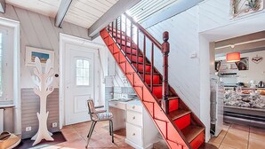 A spacious room with a red staircase, a white door, a chair, and a desk. - La Chapelle by Interhome (Tréguier)