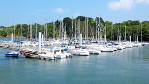 A marina with numerous boats docked, surrounded by greenery and trees. - La Chapelle by Interhome (Tréguier)
