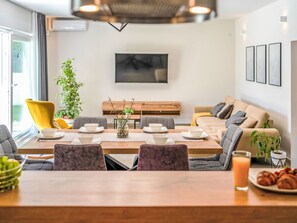 A modern living room with a dining area, a sofa, a TV, and a plant. - Vacation home Lapis by Interhome (Poreč/Sv. Lovreč)