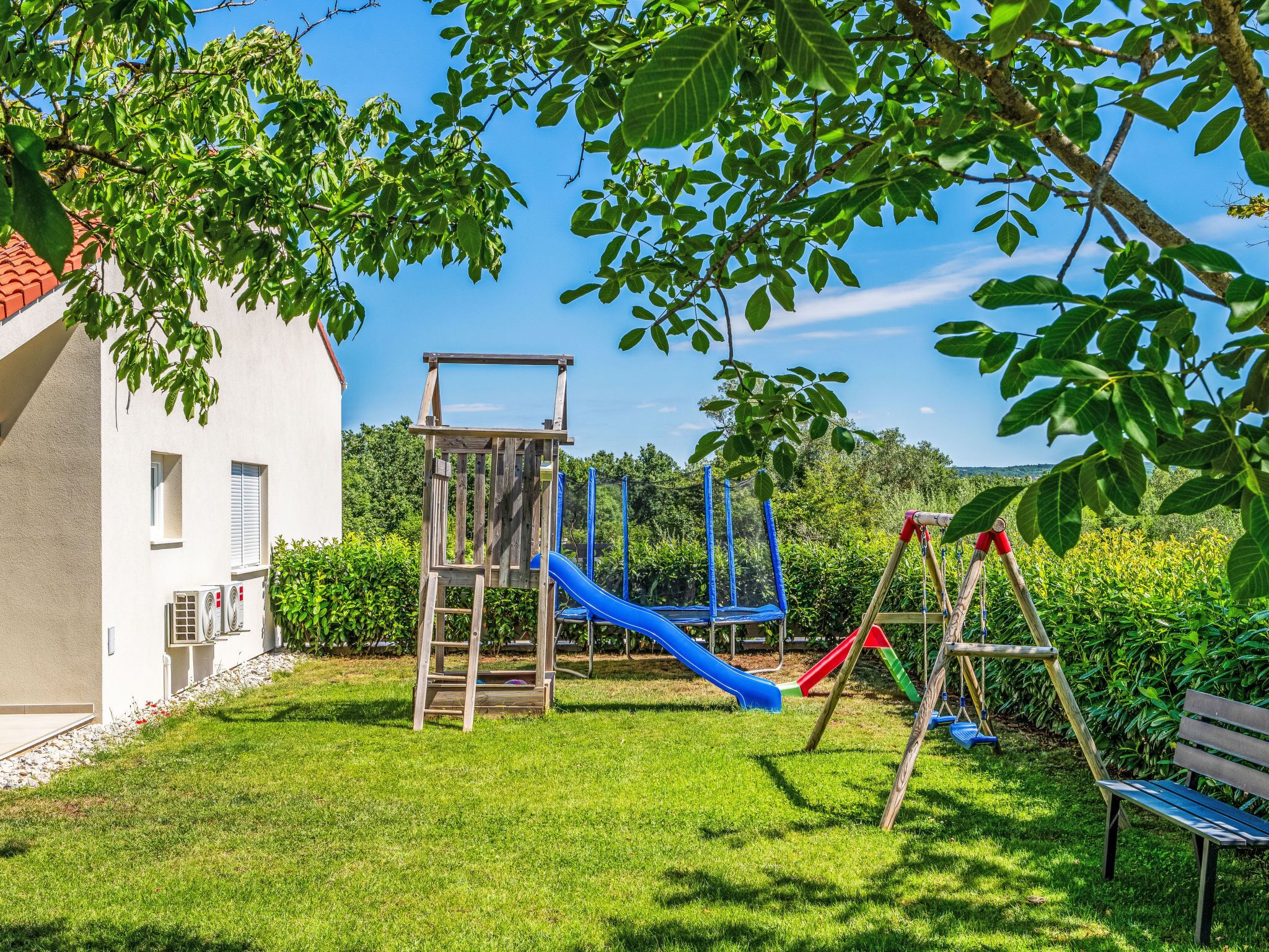 A playground with a slide, climbing structure, and swings.