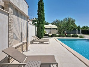 A swimming pool with lounge chairs and a tall tree. - Villa Roza by Interhome (Umag)