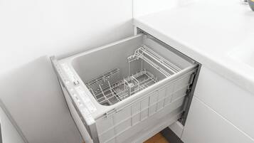 A dishwasher in a kitchen with white cabinets and a tiled floor.