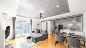 A modern living space with a sofa, dining table, and kitchen area. - ANAX NORD 502 (Sapporo)