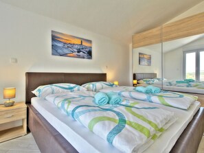 A hotel room with a bed, bedside lamps, a painting, and a large mirror reflecting the room. - Vacation home Mare by Interhome (Buje/Plovanija)