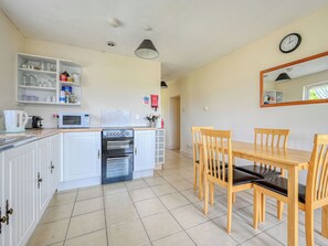 Een koelkast, een magnetron, een oven, kookgerei, borden en bestek