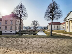 A historic building with classical architecture, a canal, and a clear sky.