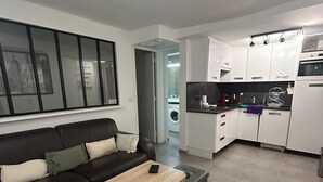 Ein modernes Wohnzimmer mit Sofa, Couchtisch und Blick zur Küche.