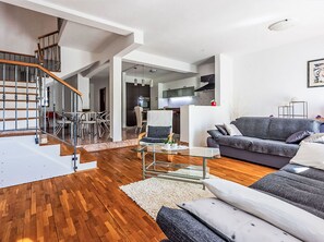 A modern living space with a staircase, a dining area, a kitchen, and a sofa. - Vacation home Deleut by Interhome (Novi Vinodolski)