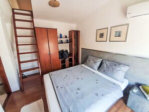 A bedroom with a bed, wardrobe, shelves, and a ladder. - Vacation home Deleut by Interhome (Novi Vinodolski)