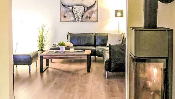 Una sala de estar con sofá, mesa de centro y chimenea.