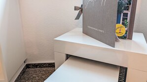 Una recepción blanca con un cartel enmarcado que dice 'Gästmappe' y 'FERIENWOHUNG KIEBITZ'.