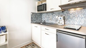 Cocina compacta equipada con microondas, cafetera y lavavajillas.