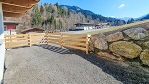A wooden building with a gravel driveway and a stone wall. - Josephine by Interhome (Auffach)