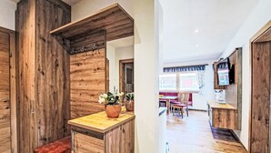 A wooden interior with a bench, a potted plant, and a dining area in the background. - Josephine by Interhome (Auffach)