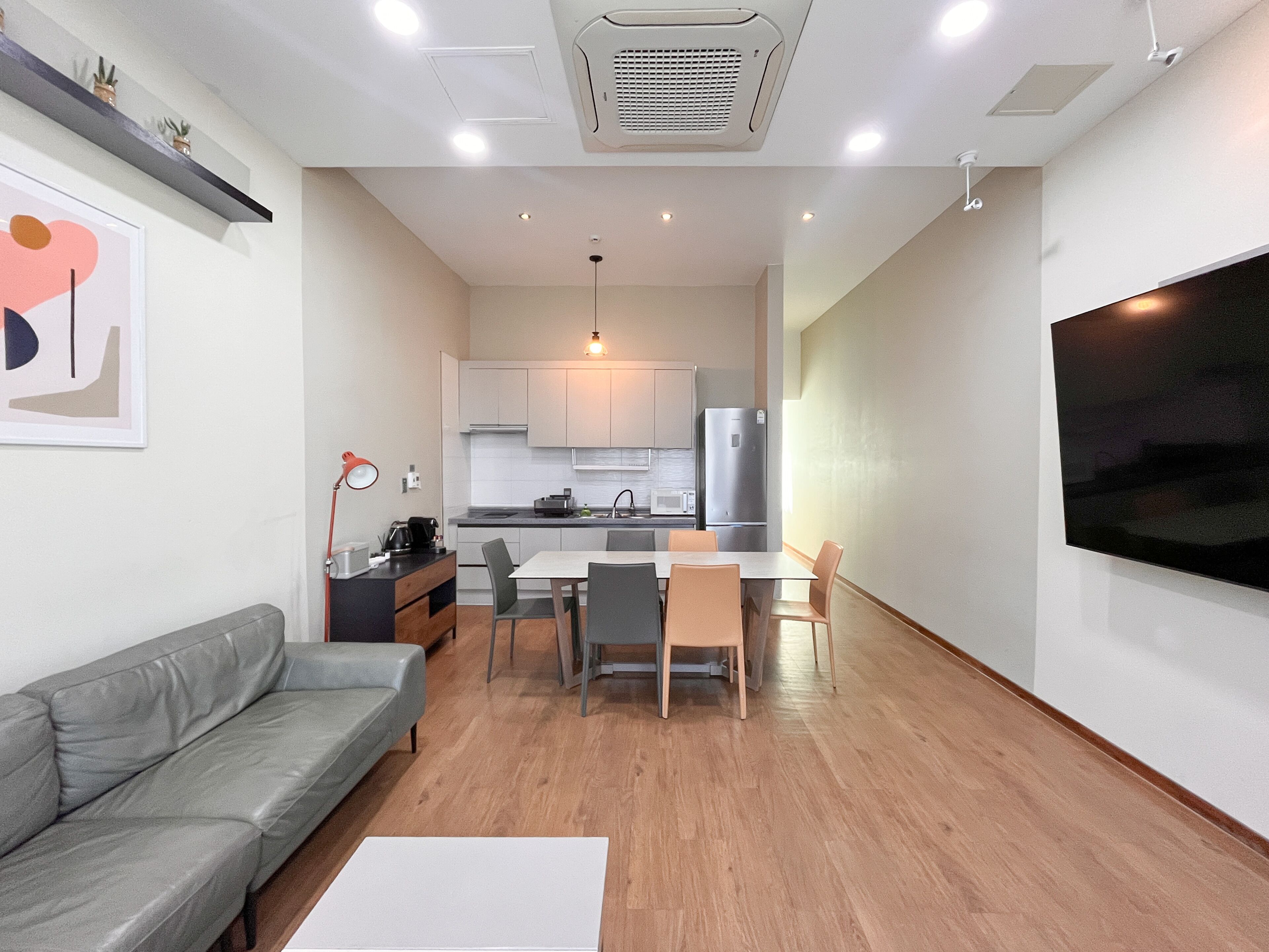 A modern apartment with a living room, dining area, and kitchen.