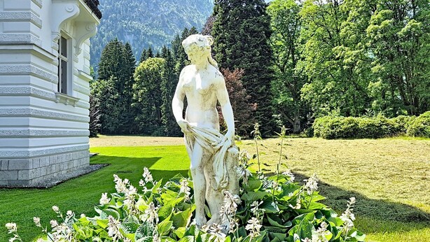 A statue in a garden with a building in the background. - im Schlosspark mit Hallenbad by Interhome (Lofer)
