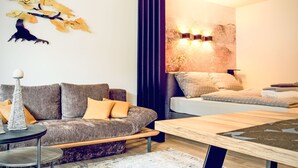 A modern living room with a sofa, a coffee table, and a wall-mounted light fixture. - im Schlosspark mit Hallenbad by Interhome (Lofer)