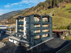A multi-story hotel with a modern design, featuring balconies, a parking area, and a view of the surrounding landscape. - Apart Kreuzjoch by Interhome (Zell am Ziller)