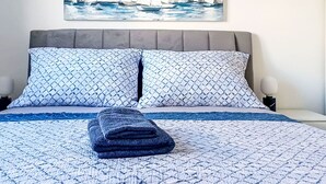 A bed with a patterned bedspread, two pillows, and a folded blanket. - Sunny Terrace II by Interhome (Trogir/Okrug Gornji)