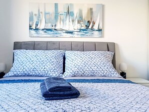 A bed with a patterned bedspread, two pillows, and a folded blanket. - Sunny Terrace II by Interhome (Trogir/Okrug Gornji)