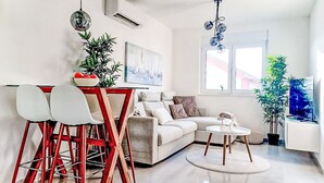 A modern living room with a sofa, dining table, chairs, and a coffee table. - Sunny Terrace II by Interhome (Trogir/Okrug Gornji)