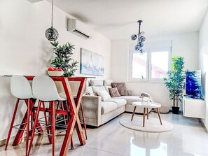 A modern living room with a sofa, dining table, chairs, and a coffee table. - Sunny Terrace II by Interhome (Trogir/Okrug Gornji)