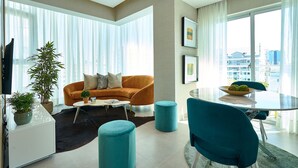 A modern living room with a sofa, coffee table, and a dining area with chairs and a table. - Artdeco Exclusive Downtownsd Gym Piantini (Santo Domingo)