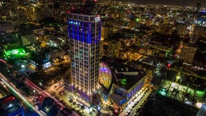 A high-rise building with a prominent 'citi' sign, surrounded by a densely populated urban area with visible roads and other buildings. - Artdeco Exclusive Downtownsd Gym Piantini (Santo Domingo)